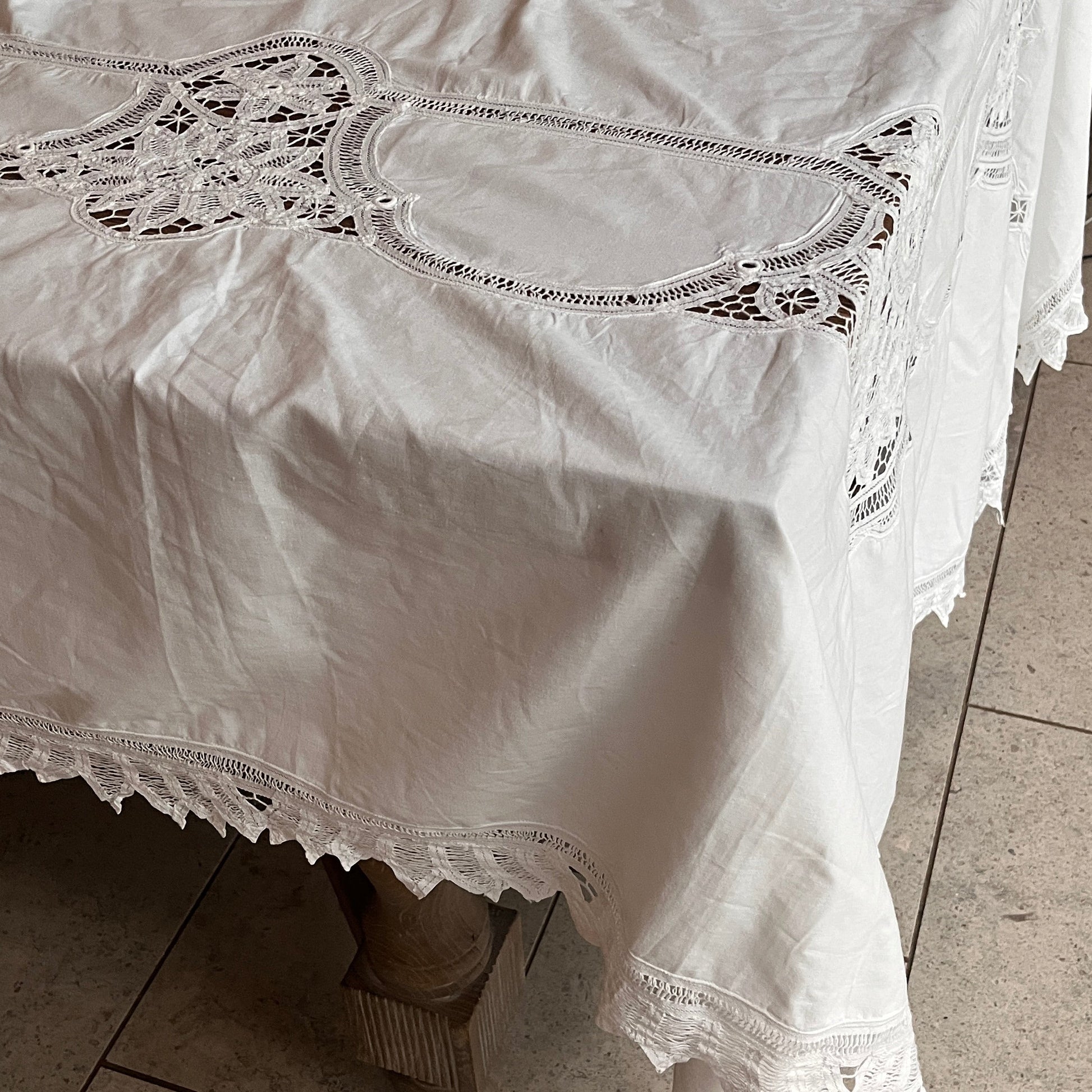 White lace dress on a tiled floor with a chair in the background