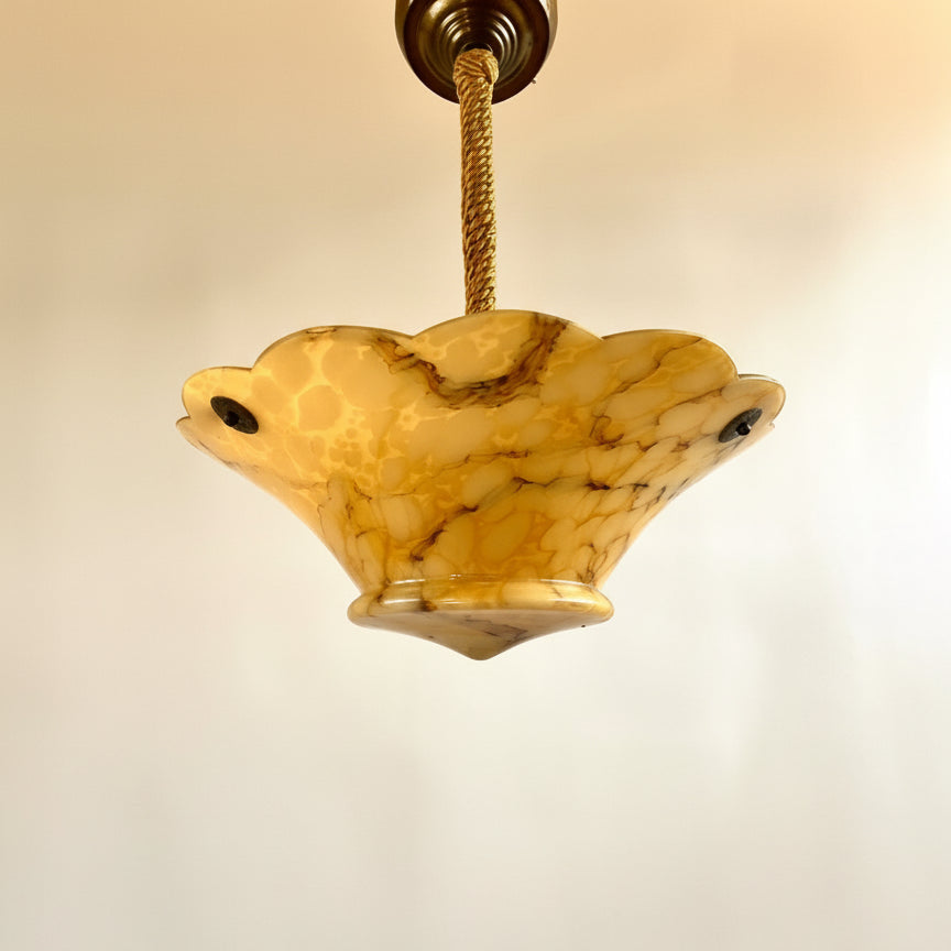 Decorative pendant light with a marble-like shade on a beige background