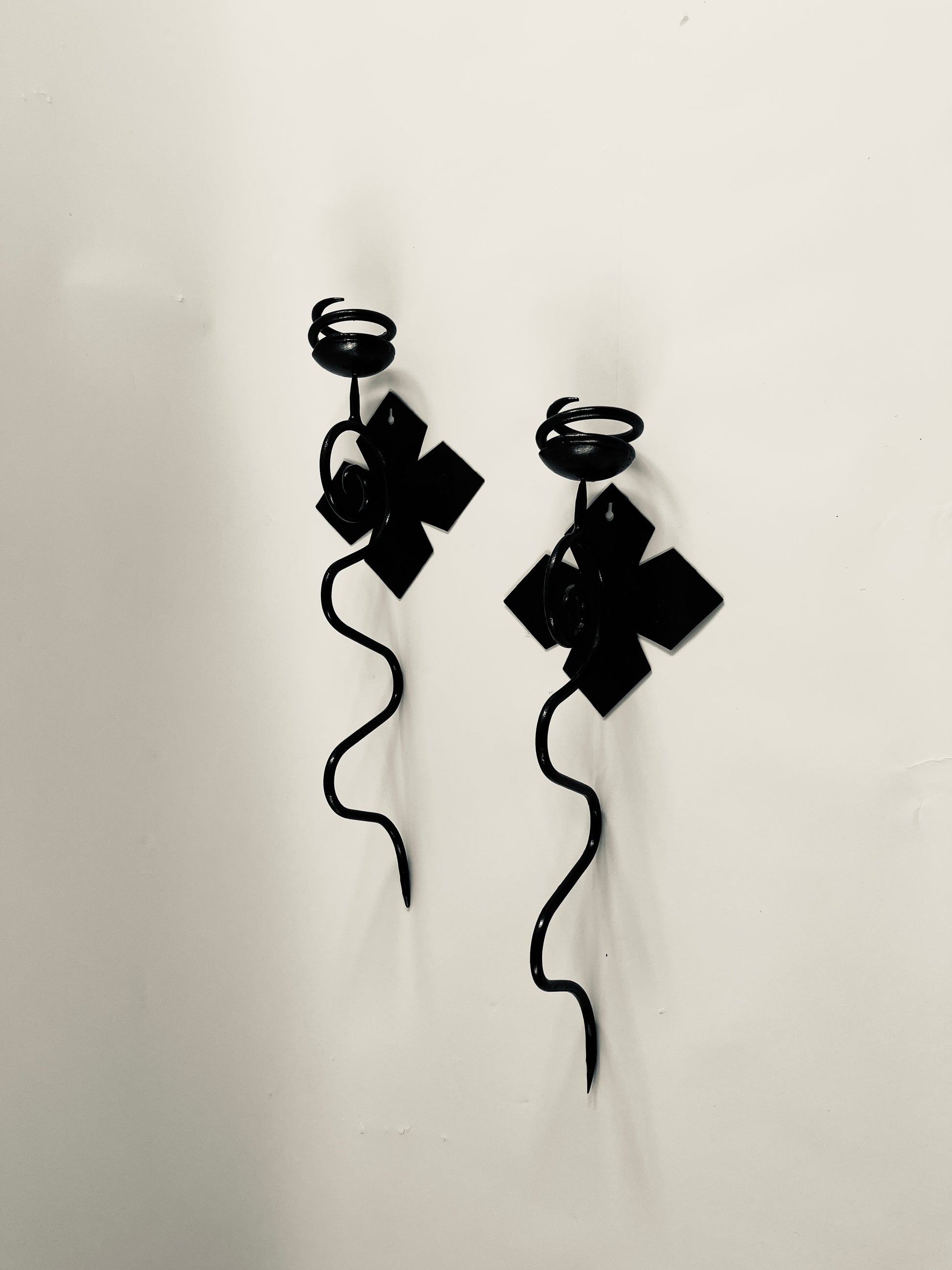 pair of black iron sconces on light grey background