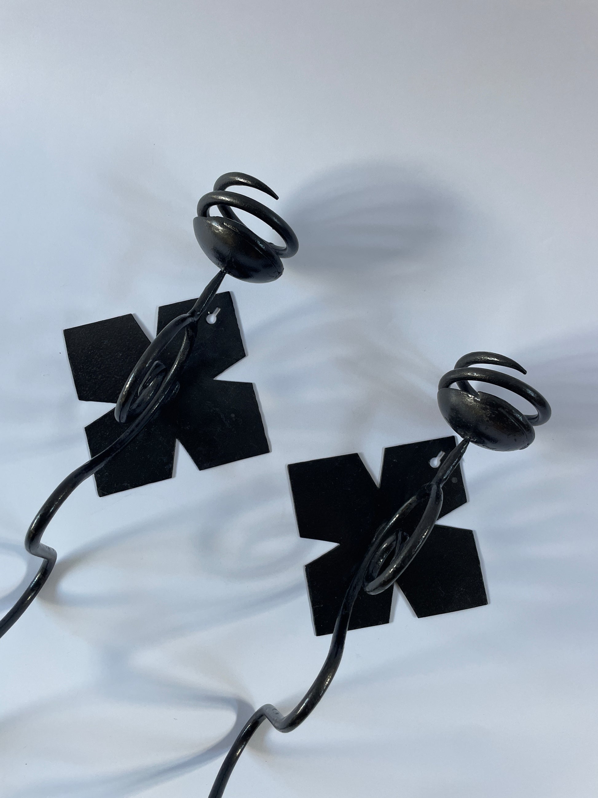 pair of black iron sconces on light grey background