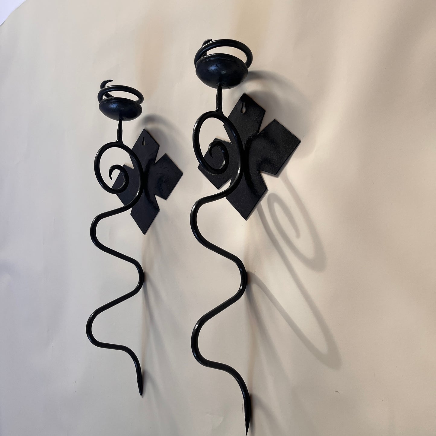 pair of black iron sconces on light grey background