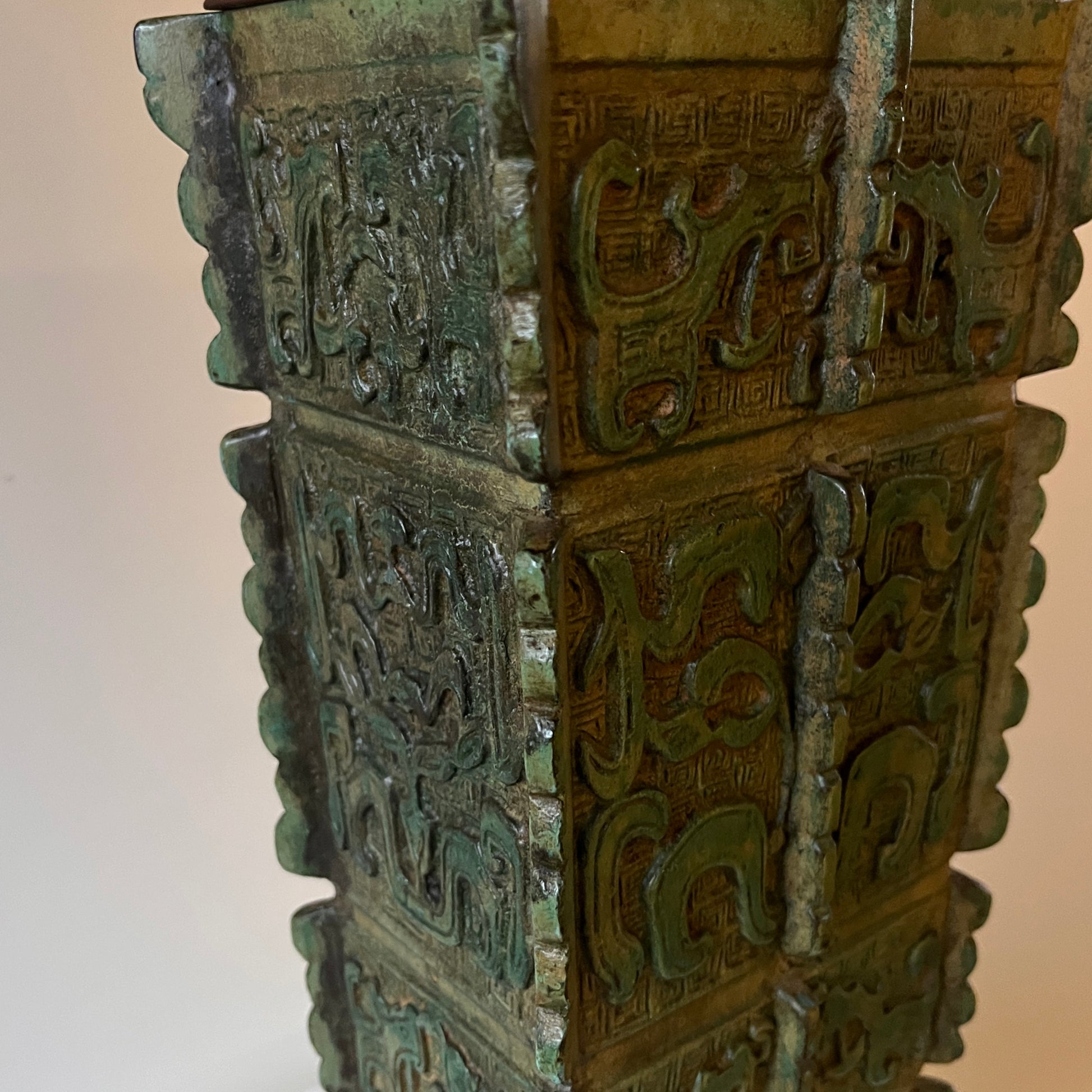 green Chinese archaic lamp base with a neutral background