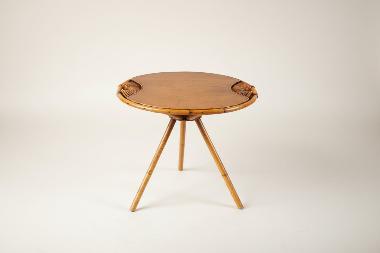 Round wooden table with wicker accents on a textured surface