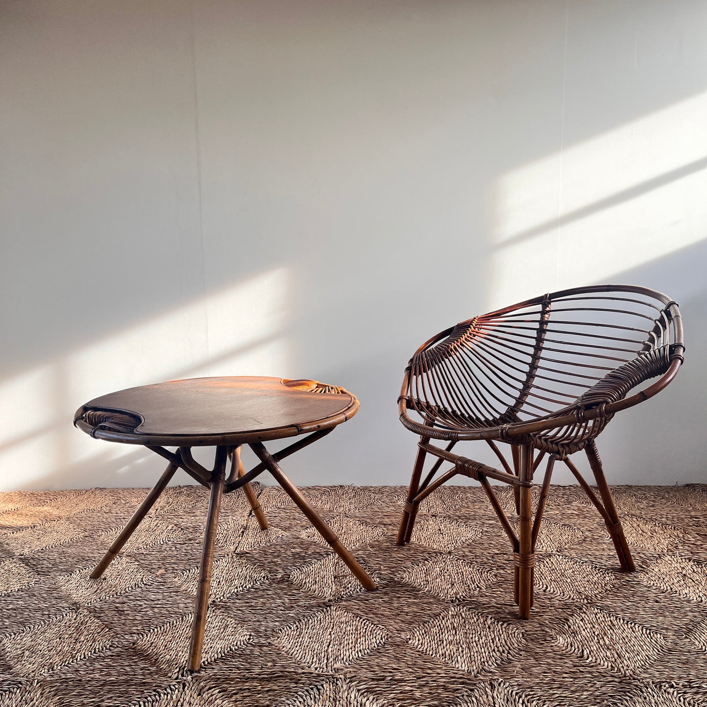 Wicker chair and table on a textured surface with a plain background