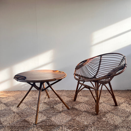 Wicker chair and table on a textured surface with a plain background