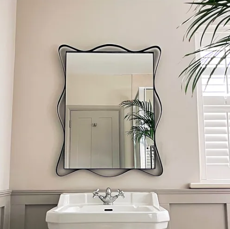 A Maud Vaughan Ribbon Mirror hung above the sink in a toilet/bathroom