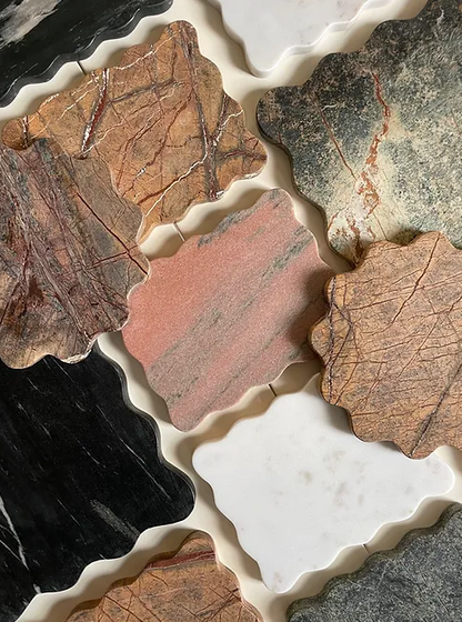 A collection of brown, pink, white, green and black small wiggly marble ondulato trays by Maud Vaughan 