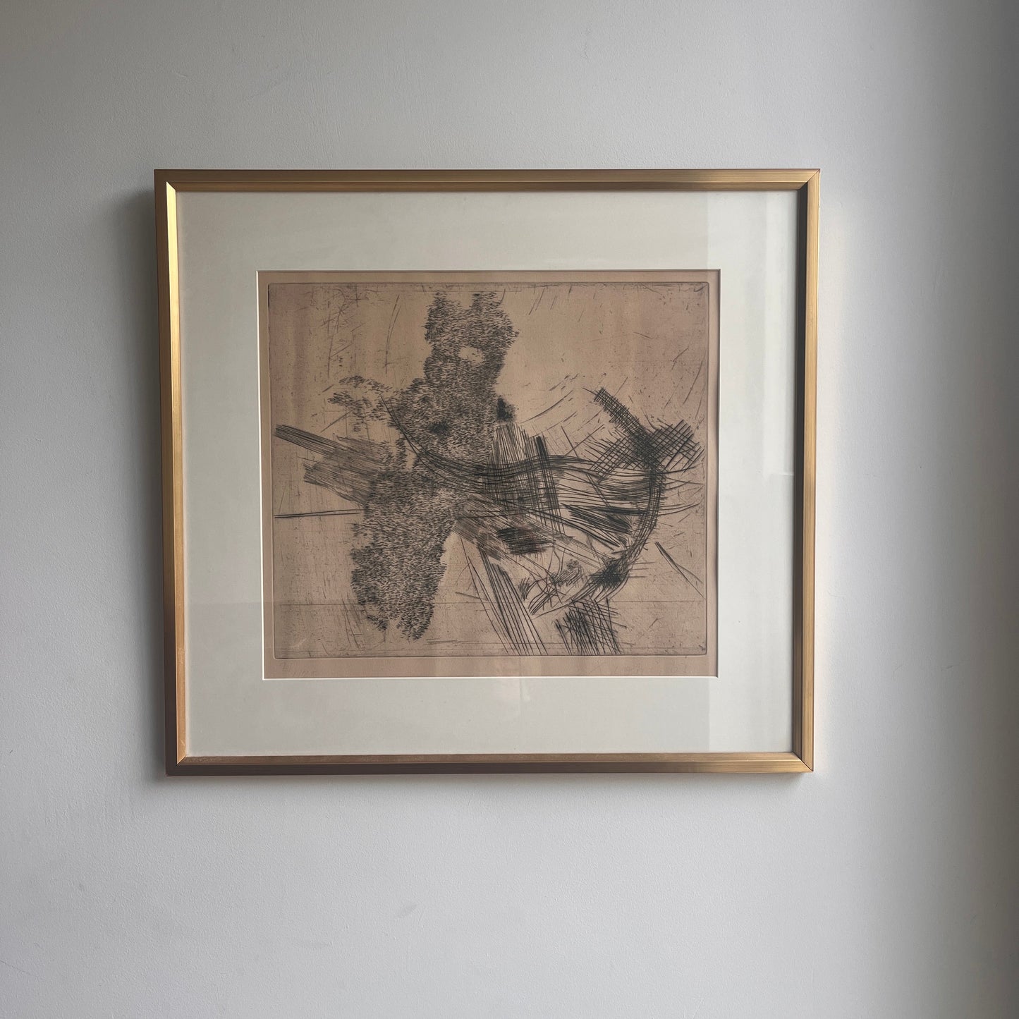 Ulf Trotzig Lithograph in a gold frame on a neutral wall